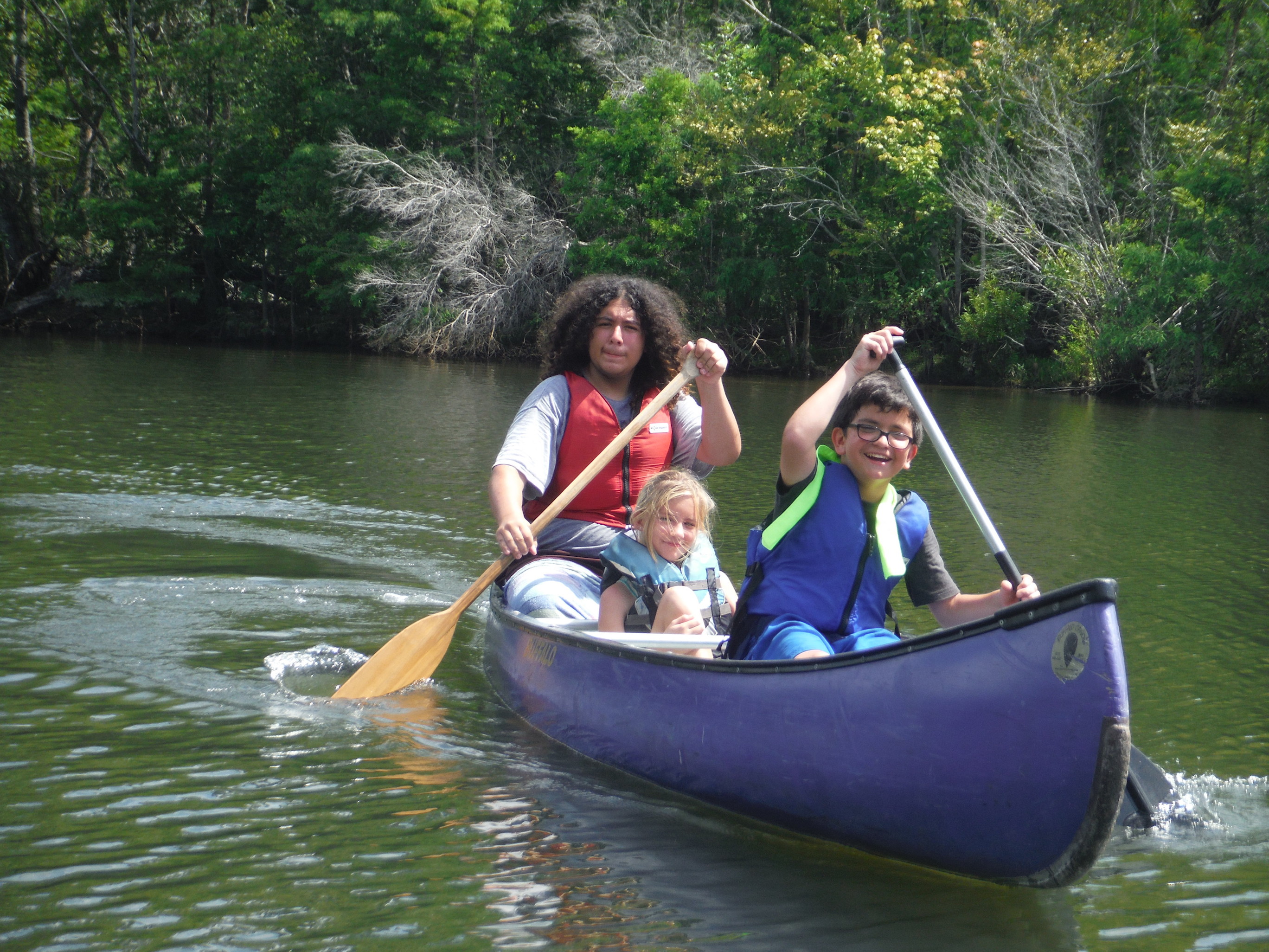 Youth having fun in a canoe at our summer leadership camp