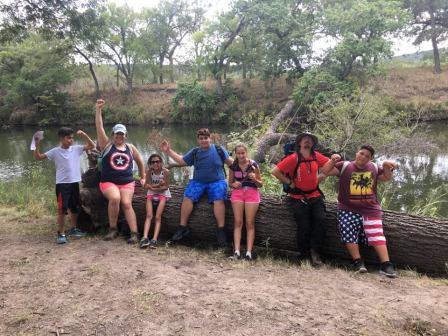 Group sitting on a fallen oak tree which is a perfect hardwood for campfires